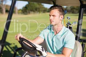 Confident young man sitting in golf buggy