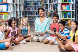 Teacher with children holding digital tablets