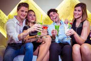 Portrait of friends enjoying cocktail in nightclub