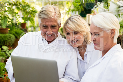 Scientists smiling while discussing over laptop