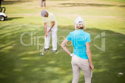 Golfer couple standing on field