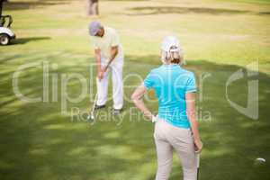 Golfer couple standing on field
