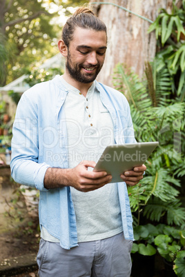 Happy owner using digital tablet at garden