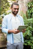 Happy owner using digital tablet at garden