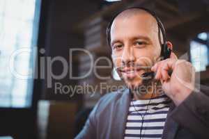 Creative businessman using headphones in office