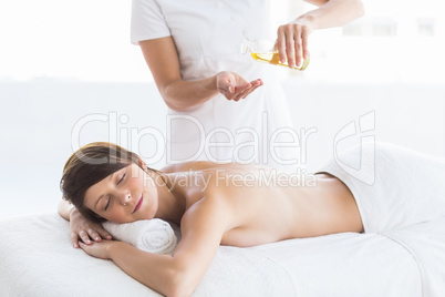 Midsection of masseur giving massage to woman