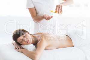 Midsection of masseur giving massage to woman
