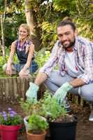 Portrait of happy gardeners crouching at garden
