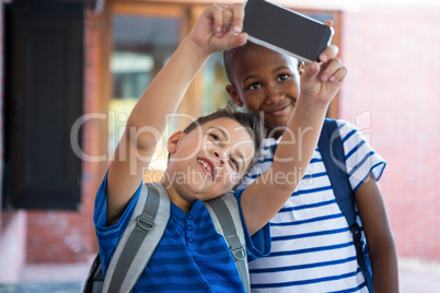 Classmates taking selfie at school corridor