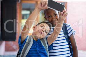 Classmates taking selfie at school corridor