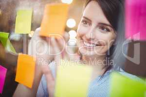 Creative businesswoman writing on sticky notes