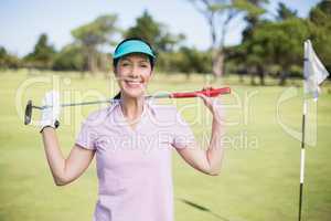 Portrait of happy woman carrying golf club