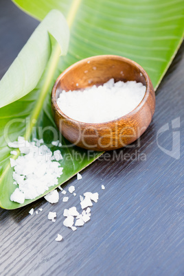 Salt in bowl with banana leaf on table
