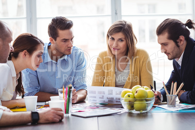 Attractive photo editor with coworkers in meeting room