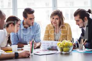 Attractive photo editor with coworkers in meeting room