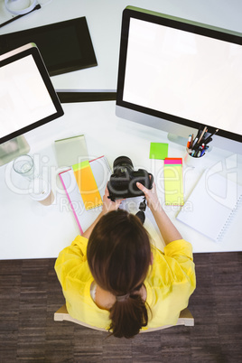 Overhead view of photographer with camera sitting at creative of