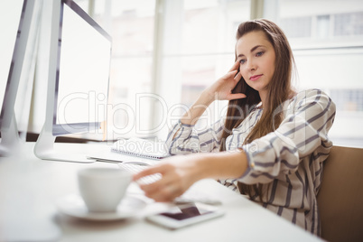 Businesswoman holding coffee cup in creative office