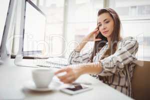 Businesswoman holding coffee cup in creative office