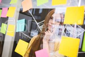 Thoughtful businesswoman looking on sticky notes