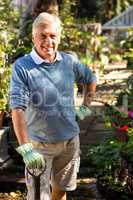 Portrait of happy gardener with shovel at garden