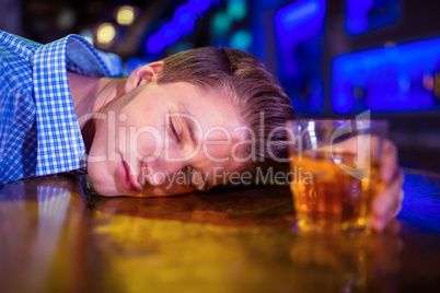 Drunk man lying on bar counter