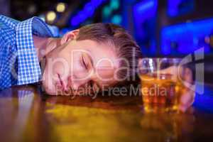 Drunk man lying on bar counter
