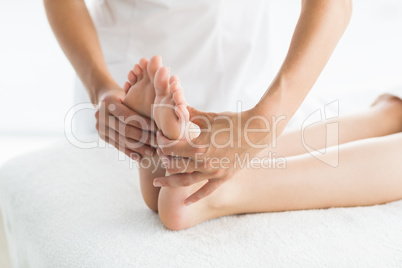 Cropped image of masseur giving foot massage to woman