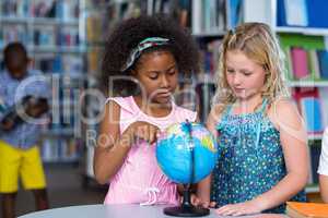 Girls looking at globe