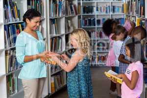 Teacher giving books to girl