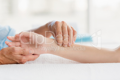 Cropped image of masseur giving hand massage to woman