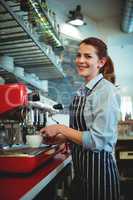Portrait of waitress pouring coffee from espresso maker