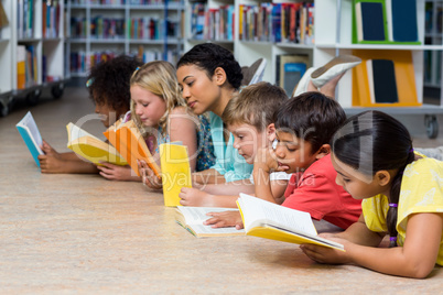 Teacher with students reading books while lying down