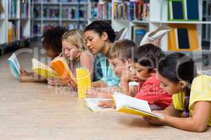 Teacher with students reading books while lying down