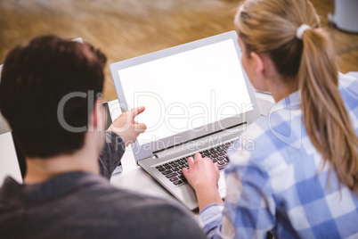 Rear view of executives using laptop at creative office