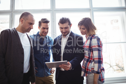Businessman showing digital tablet to colleagues