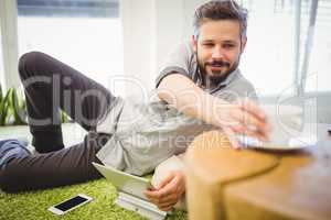 Businessman taking coffee cup while relaxing at creative office
