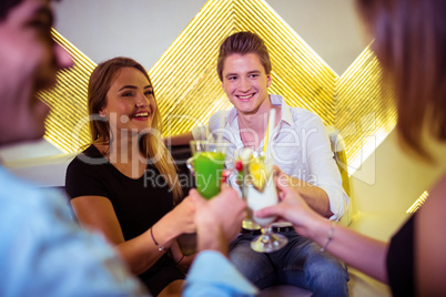 Joyful friends toasting cocktail