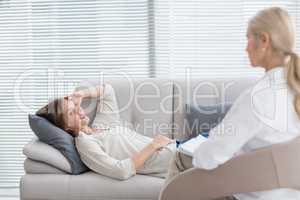 Woman lying on sofa talking to therapist