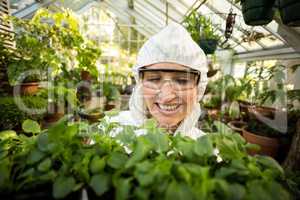Female scientist smiling while holding plants