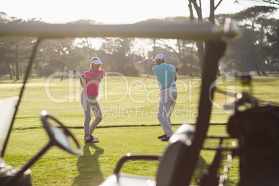 Mature couple playing golf