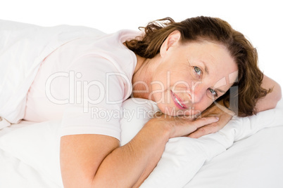 Portrait of happy mature woman lying on bed
