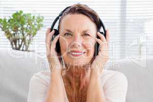 Portrait of happy mature woman listening to music
