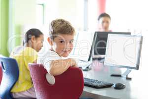 Boy with classmates and teacher in computer room