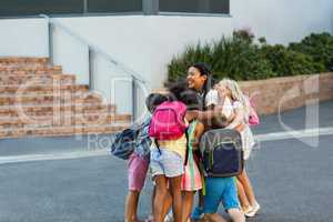 Schoolchildren embracing teacher