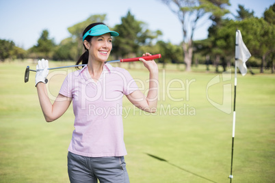 Happy woman carrying golf club