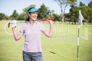 Happy woman carrying golf club