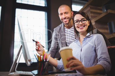 Happy coworkers working at computer desk