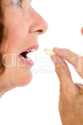 Cropped image of woman taking pill