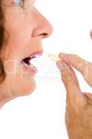 Cropped image of woman taking pill