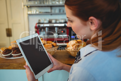Barista using tablet computer at cafe
